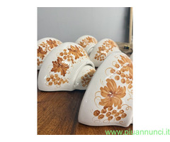 Gruppo di sei applique in ceramica dipinte a mano